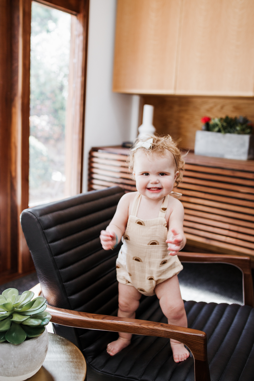 baby standing on black chair