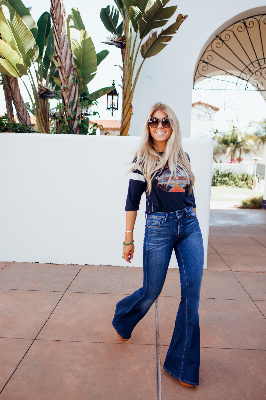 lisa allen of salty lashes wearing a football style Journey Tee with L'agence flare jeans and chloe sunglasses