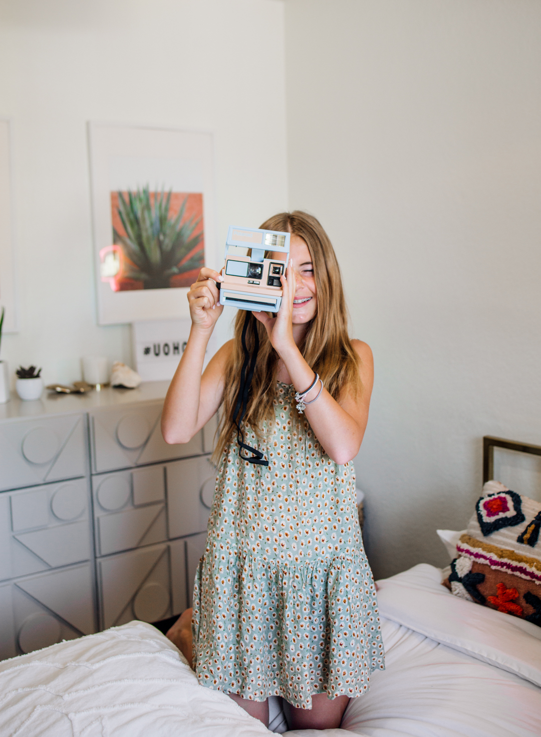 a teen girl holding a polaroid camera | How To Style a Teen's Bedroom