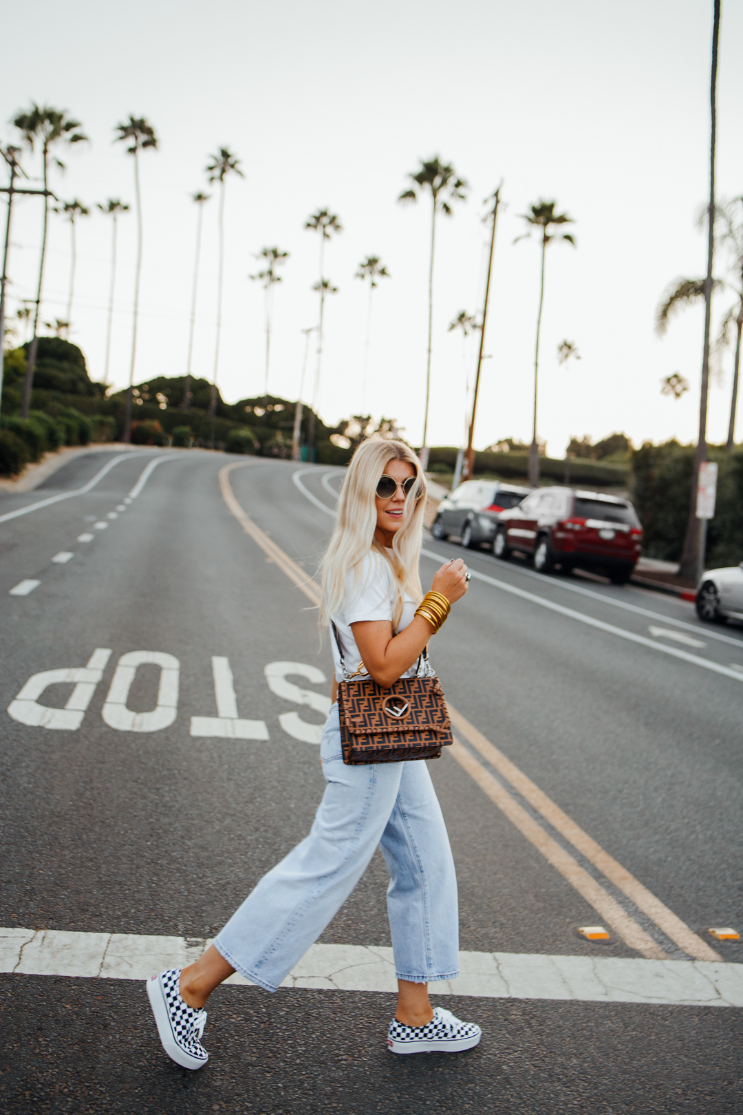lisa allen of salty lashes wearing cropped wide leg legs with platforms and a white tee with a fendi bag