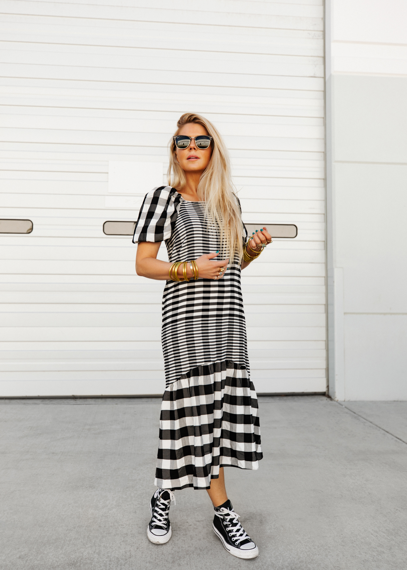 Best Casual Dresses For Spring - Salty Lashes wearing a checker dress, Converse, sunglasses and bracelets.