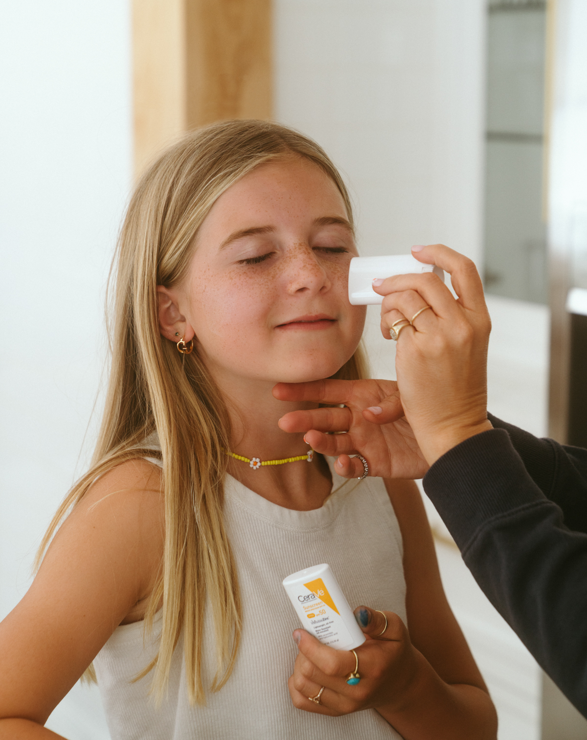 Applying CeraVe sunscreen stick on little girl