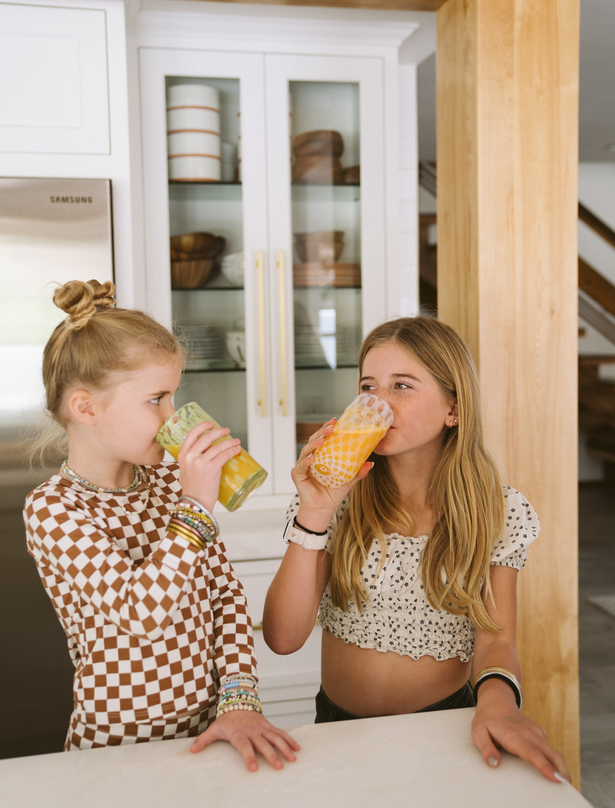 two kids drinking orange juice