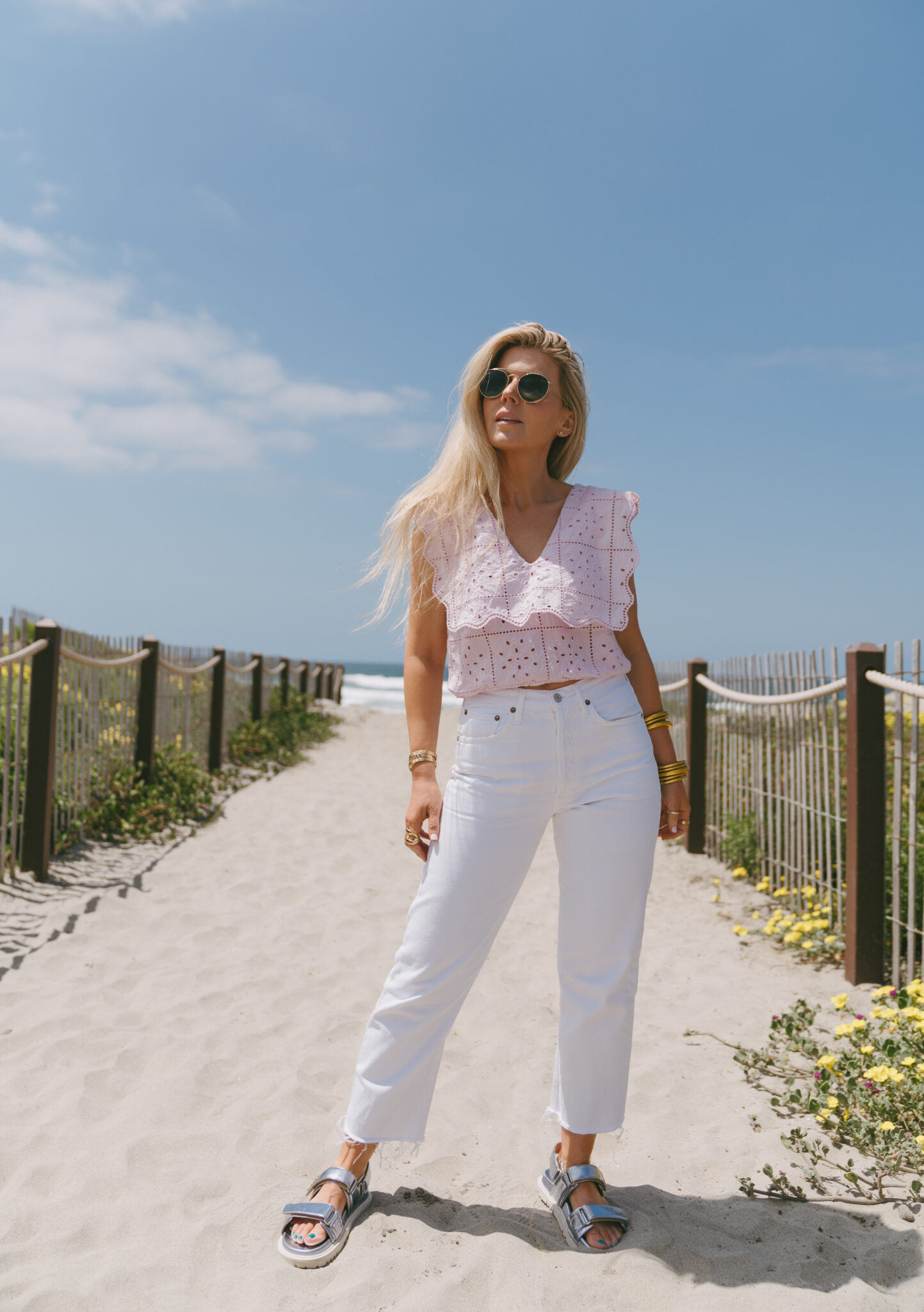 woman at the beach wearing pink eyelet top, white pants from Summer Styles With Nordstrom