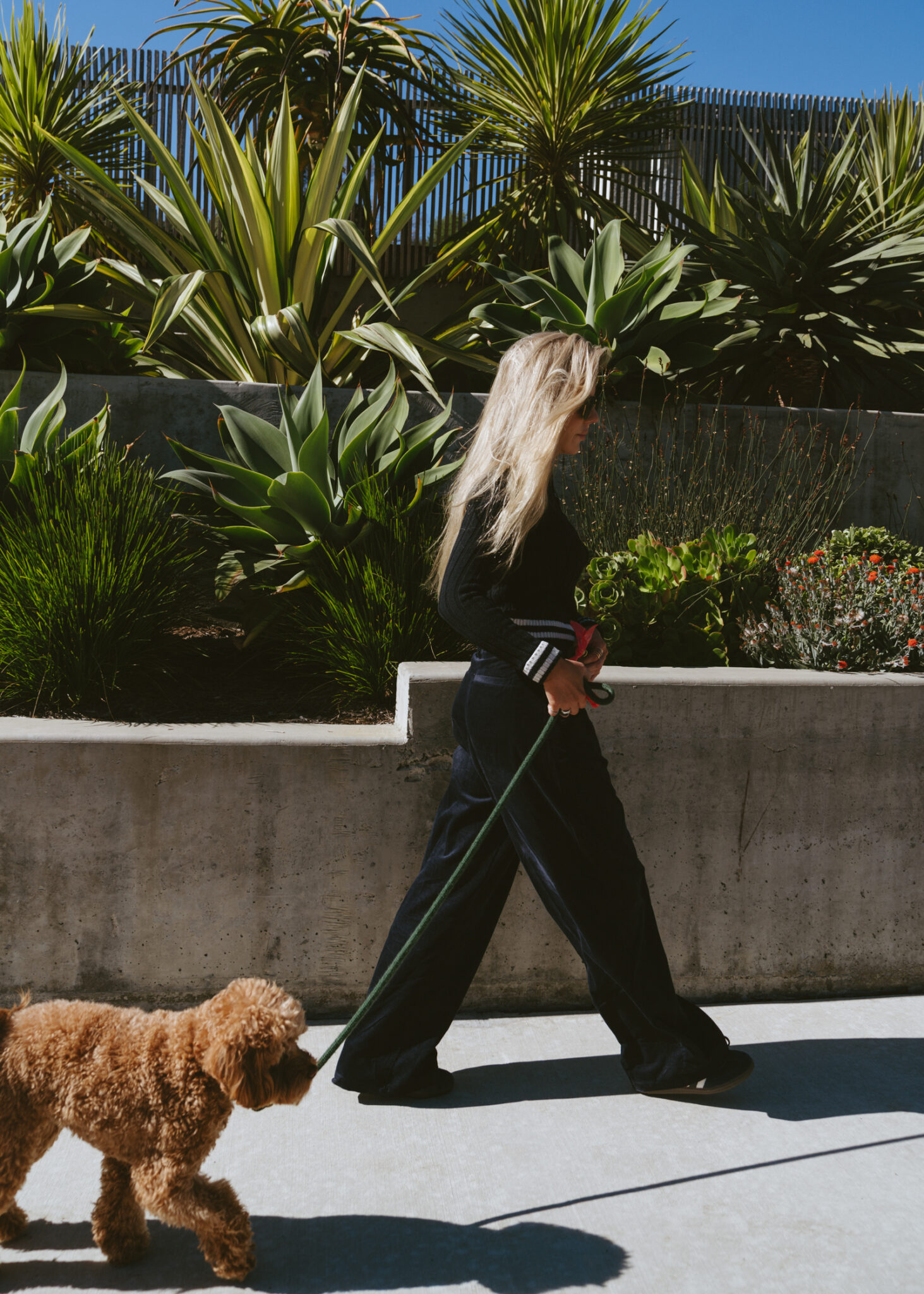 woman walking her dog and wearing black pants from UO Holiday Wishlist