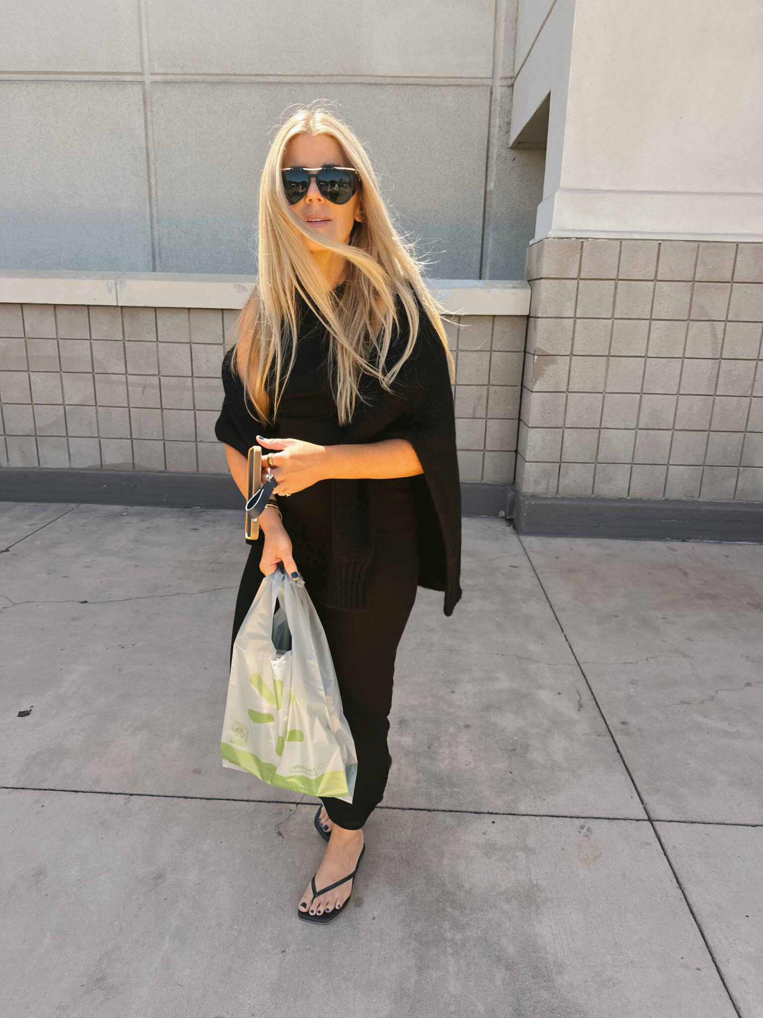 Salty Lashes Blogger Lisa Allen in all black outfit and holding a grocery bag